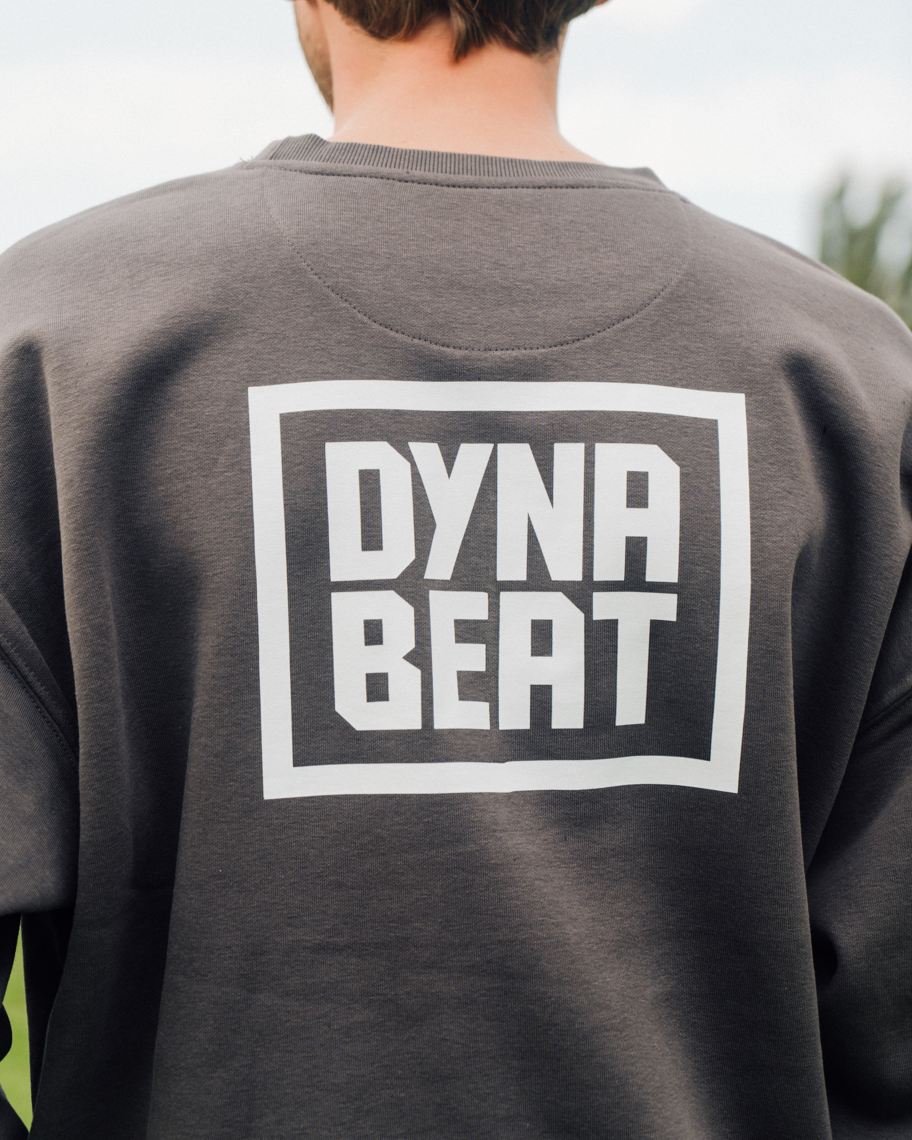 Rückseite des grauen DYNABEAT Crewnecks mit großem Logo
